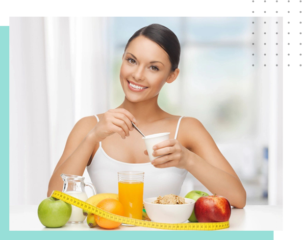 A woman sitting at the table with fruit and cereal.